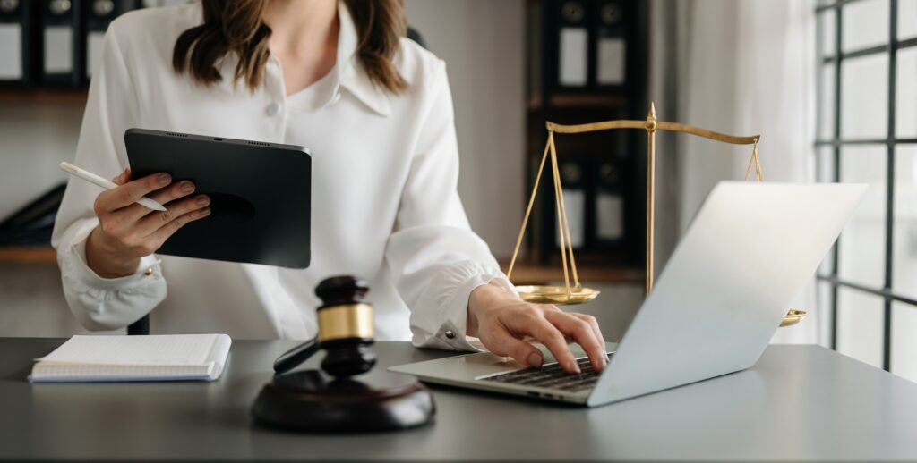 justice and law concept.Male judge in a courtroom the gavel, working with smart phone and laptop